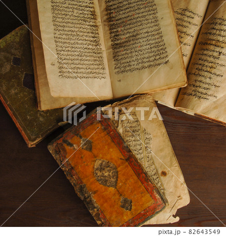 Stack of open ancient books in Arabic. Old Arabic manuscripts and texts. Top view Stack of open ancient books in Arabic. Old Arabic manuscripts and texts. Top view 82643549