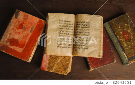 Stack of open ancient books in Arabic. Old Arabic manuscripts and texts. Top view Stack of open ancient books in Arabic. Old Arabic manuscripts and texts. Top view 82643551