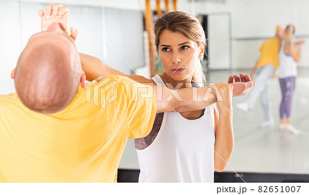 Woman performing palm heel strike while training in gym Woman performing palm heel strike while training in gym 82651007