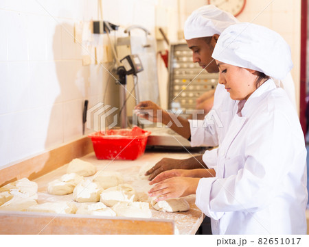 Woman baker shaping dough before baking Woman baker shaping dough before baking 82651017
