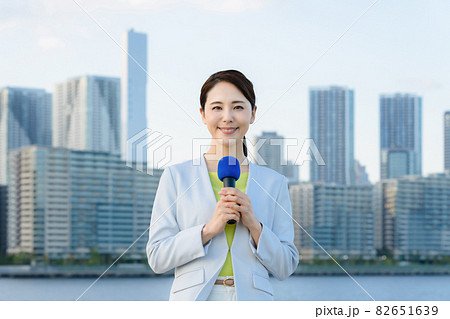都市の前に立つ女性アナウンサー 82651639