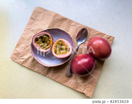 【盛り付けイメージ画像】半分に切ったピンク色のパッションフルーツと果肉 82653629