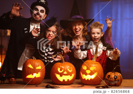 Young family mother father and children in Halloween costumes celebrating all hallows eve at home Young family mother father and children in Halloween costumes celebrating all hallows eve at home 82656868
