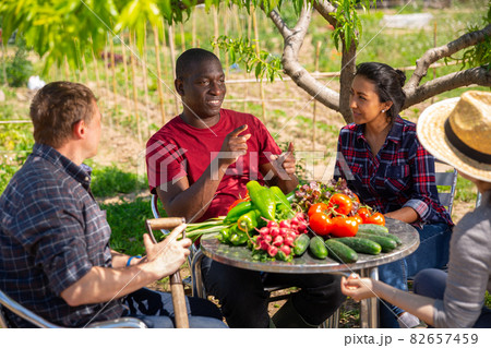 Good friends have conversation at table in backyard of village house Good friends have conversation at table in backyard of village house 82657459