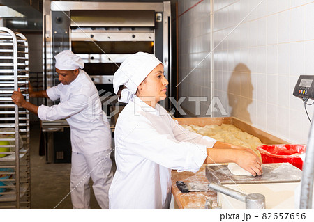 Baker weighs dough on scales in bakery Baker weighs dough on scales in bakery 82657656