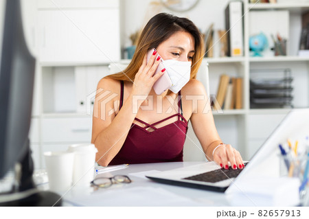 Young peruvian woman manager in mask using phone Young peruvian woman manager in mask using phone 82657913