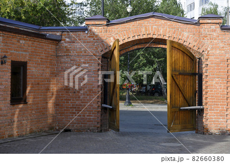 Wooden half-open gate in a brick fence in 19th century merchant Kazakov's house in Kazan, Russia 82660380