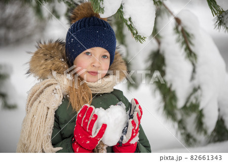 Happy child girl plaing with snow with heart made of snow. 82661343