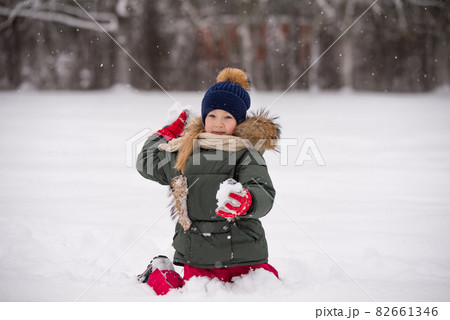 Happy child girl plaing with snow on a snowy winter walk 82661346
