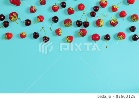 Fresh cherries and strawberries on mint background, top view 82663128