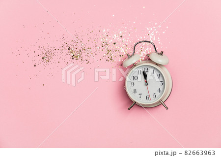 Creative composition with alarm clock and golden stars confetti on pink background Creative composition with alarm clock and golden stars confetti on pink background 82663963