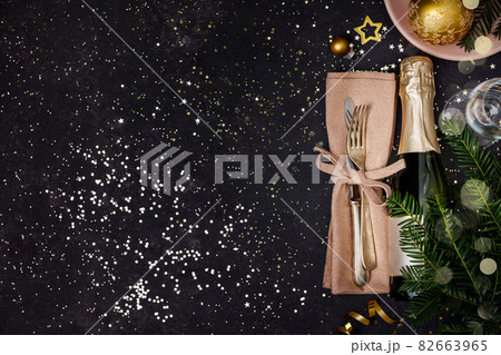 Champagne bottle with christmas decoration on dark background Champagne bottle with christmas decoration on dark background 82663965