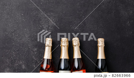 Four champagne bottles on dark background, flat lay Four champagne bottles on dark background, flat lay 82663966