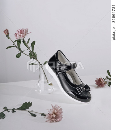 Stylish new shoes for school for a girl in a composition of flowers Stylish new shoes for school for a girl in a composition of flowers 82664785