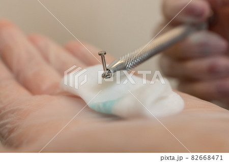 ear jewelry, piercing in hand with a disposable glove. 82668471