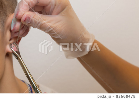 Professional holding the jewel of piercing just before screw the ball. 82668479