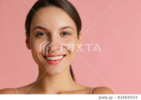Close-up portrait of young beautiful girl without makeup isolated over pink studio background. Natural beauty concept. 82669503