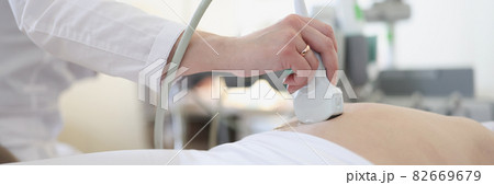 Ultrasound scanner device in hand of professional doctor examining his patient Ultrasound scanner device in hand of professional doctor examining his patient 82669679