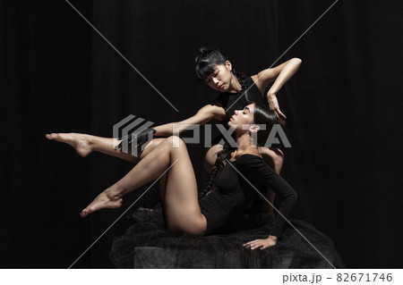 Modern ballet performance. Two beautiful girls, modern dancers in art performance isolated on dark background. Feelings, emotions concept 82671746