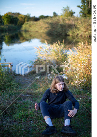 Man with long hair with lake behind 82675690