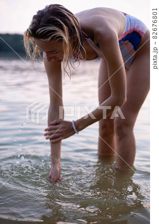 Girl with blonde hair with lake behind Girl with blonde hair with lake behind 82676801
