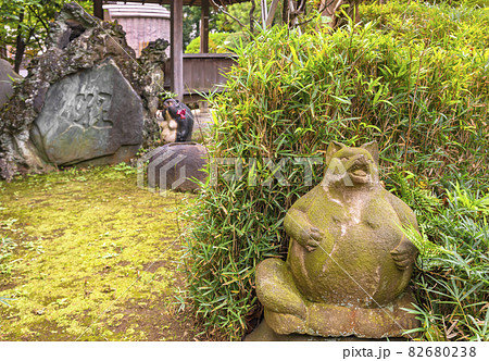 東京 堀切 隅田川七福神の多聞寺に立つ苔に覆われたポケモンみたいなタヌキの彫刻 の写真素材