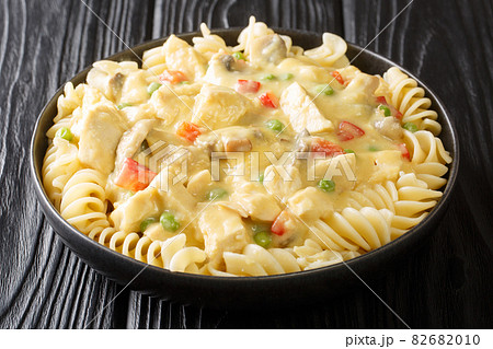 American food stewed chicken a la King in a creamy sauce with mushrooms served with pasta close-up in a plate. horizontal 82682010