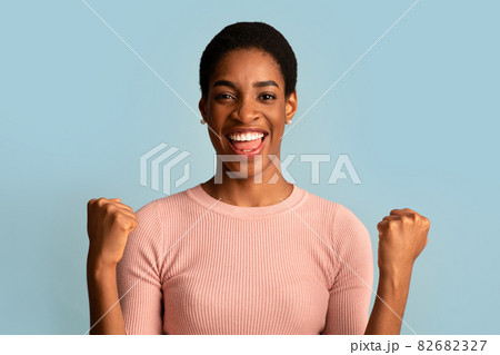 Big Luck. Overjoyed Black Woman Raising Fists And Exclaiming With Excitement Big Luck. Overjoyed Black Woman Raising Fists And Exclaiming With Excitement 82682327