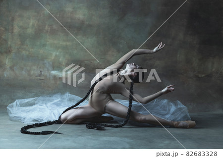 Portrait of young professional ballet dancer, attractive ballerina dancing isolated over dark retro background 82683328