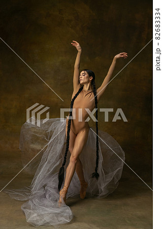Full-length portrait of young, beautiful ballerina posing isolated over studio background 82683334