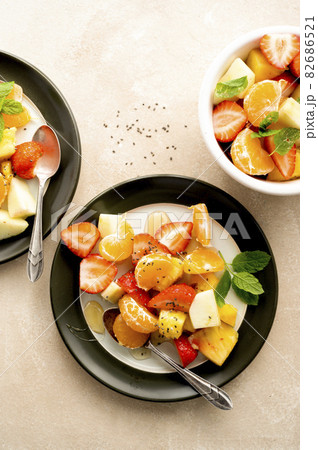 Fruit salad for breakfast, mix of with fresh apple, strawberry, tangerines, pineapple and honey. Fruit salad for breakfast, mix of with fresh apple, strawberry, tangerines, pineapple and honey. 82686521
