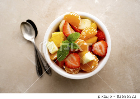 Fruit salad with fresh apple, strawberry, tangerines, pineapple and honey. Diet and healthy eating Fruit salad with fresh apple, strawberry, tangerines, pineapple and honey. Diet and healthy eating 82686522