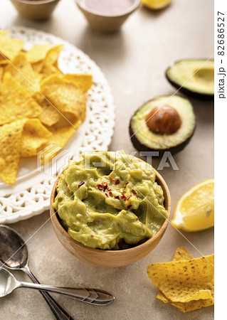 Guacamole dip with corn chips - nachos on bright background, party food 82686527