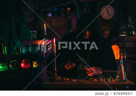 alchemist magician sorcerer does experiments with a potion in a laboratory alchemist magician sorcerer does experiments with a potion in a laboratory 82689667