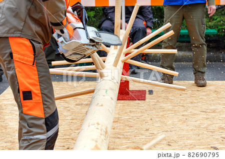 Lumberjack competition, a worker dexterously demonstrates the ability to handle a chainsaw in the workplace. Lumberjack competition, a worker dexterously demonstrates the ability to handle a chainsaw in the workplace. 82690795