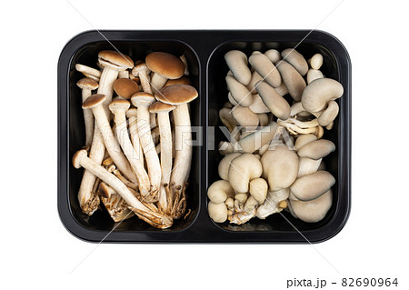 Mushrooms in a black container on a white background. Fresh mushrooms in a plastic container close-up. 82690964