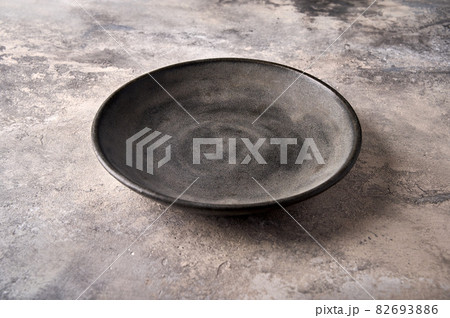 Empty dark deep plate on gray textured background as concrete. Copy space Empty dark deep plate on gray textured background as concrete. Copy space 82693886