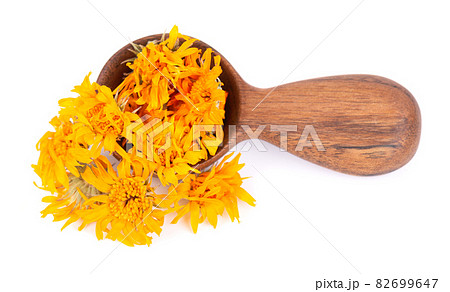Dried calendula flowers in wooden spoon, isolated on white background. Petals of Calendula officinalis. Medicinal herbs. Dried calendula flowers in wooden spoon, isolated on white background. Petals of Calendula officinalis. Medicinal herbs. 82699647