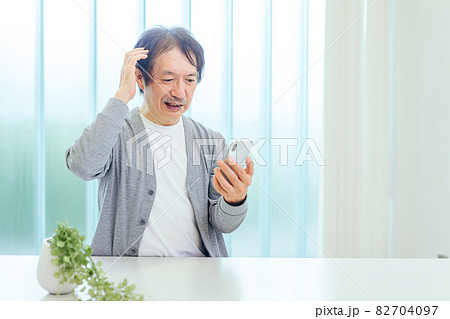 スマホを使う中高年男性（アプリ・困る） 82704097