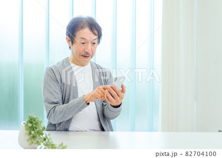 スマホを使う中高年男性（アプリ・驚く） 82704100