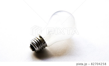 白背景に置かれた光り輝く白熱電球	 82704258