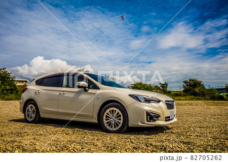 青空の中を飛ぶパラグライダーと砂利道に停められた白い自動車 青空の中を飛ぶパラグライダーと砂利道に停められた白い自動車 82705262