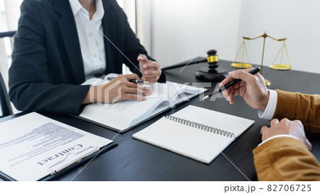 law,libra scale and hammer on the table, 2 lawyers are discussing about legal provision, law matters determination 82706725