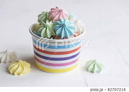 Small colorful meringues in the paper bowl Small colorful meringues in the paper bowl 82707216