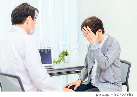 パソコンで診察するマスク姿の男性医師（頭痛） 82707865