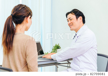 診察する男性医師と女性患者(ノートパソコン) 診察する男性医師と女性患者(ノートパソコン) 82709081