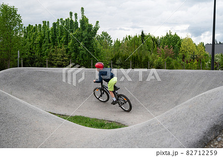 Young boy riding a pump track with bmx bike 82712259