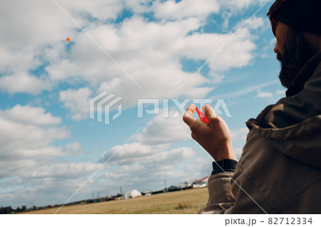 Young man flying a kite against blue sky Young man flying a kite against blue sky 82712334