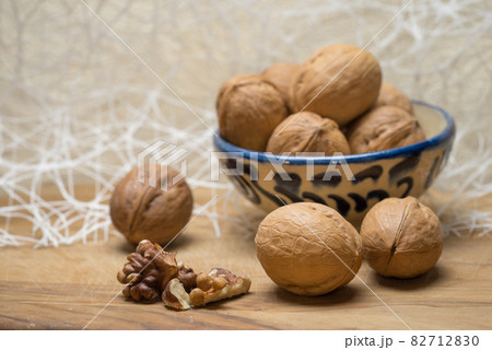 Walnut chopped nuts kernels and whole walnuts lie on a wooden table. Walnut chopped nuts kernels and whole walnuts lie on a wooden table. 82712830
