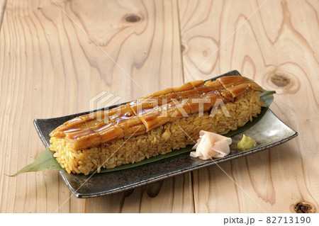 笹の葉に置かれた穴子の姿鮨とガリと山葵 82713190